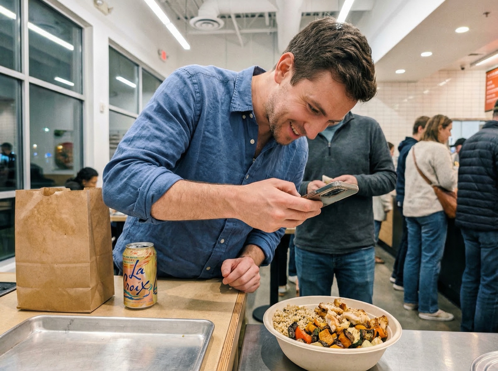 Man photographing his lunch at a fast-casual restaurant counter before logging it